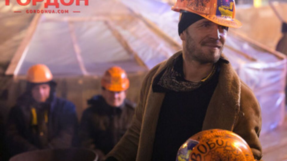 Строитель-художник расписывает каски на Евромайдане. Фоторепортаж