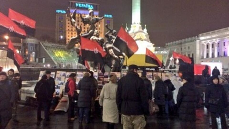 На площади собрались несколько десятков человек с черно-красными флагами