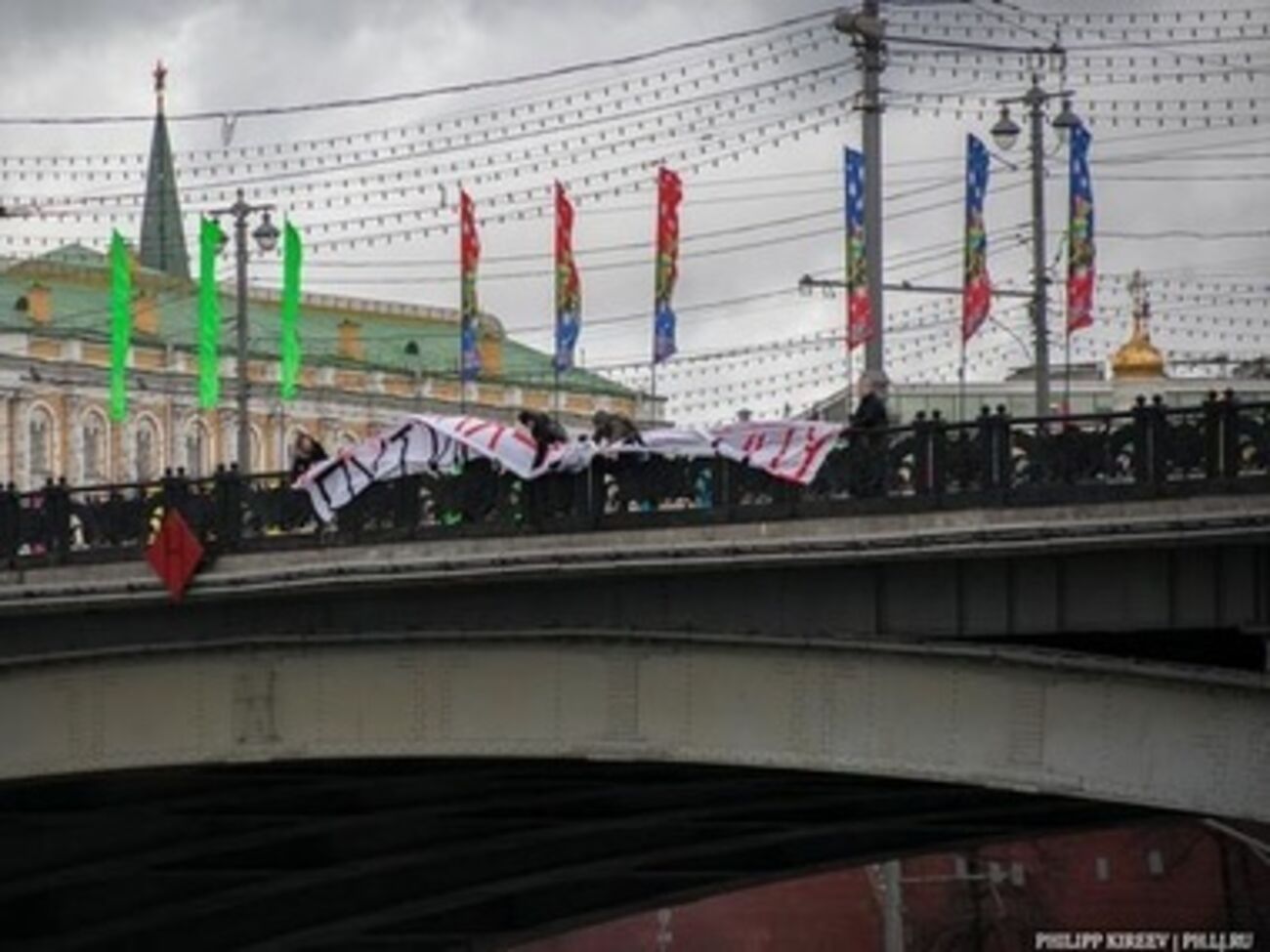 Активисты разворачивают антипутинский баннер на фоне Кремля