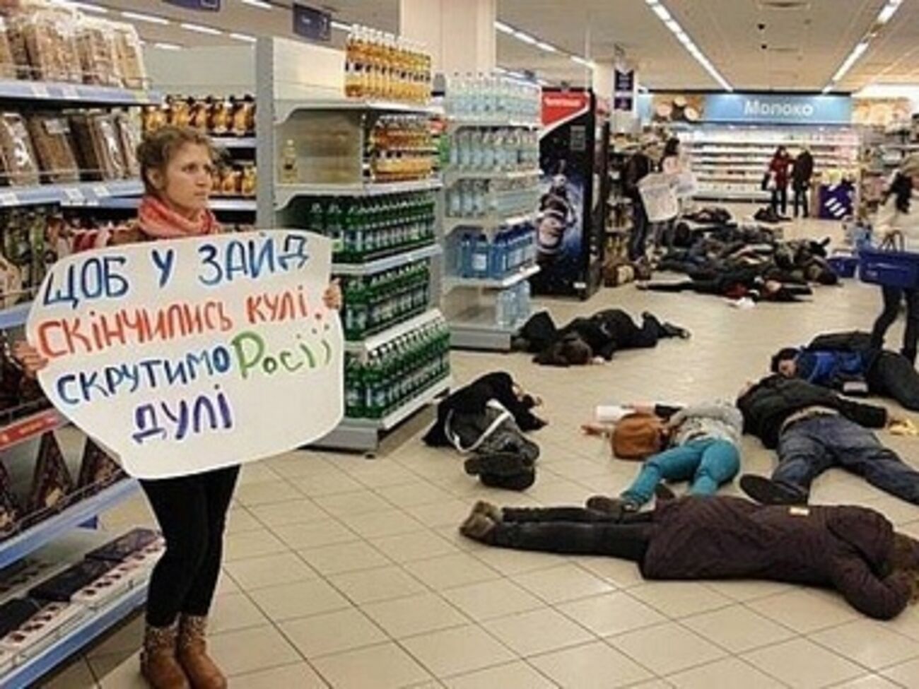 Активисты с плакатами ложатся на пол в торговых центрах, символизируя украинских граждан, которые могут быть убиты российскими военными