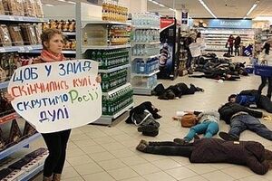 Активисты с плакатами ложатся на пол в торговых центрах, символизируя украинских граждан, которые могут быть убиты российскими военными