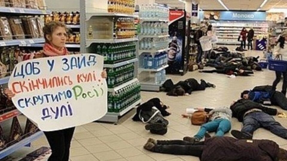 Активисты с плакатами ложатся на пол в торговых центрах, символизируя украинских граждан, которые могут быть убиты российскими военными