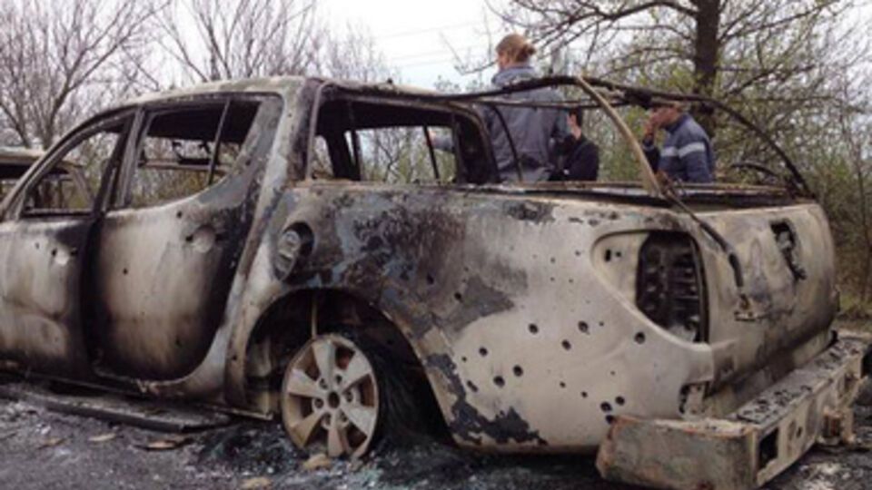 Сожженная машина, в которой были неизвестные нападавшие на блокпост "самообороны" у въезда в Славянск