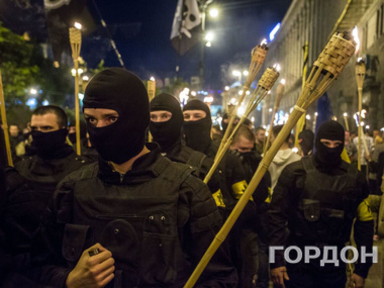 Возглавляли шествие активисты в черных бронежилетах и балаклавах