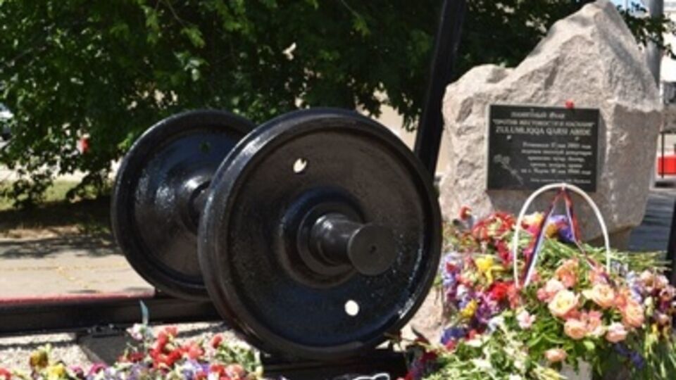 К памятнику жертвам депортированных народов возложили цветы, среди которых было много желтых и синих ирисов