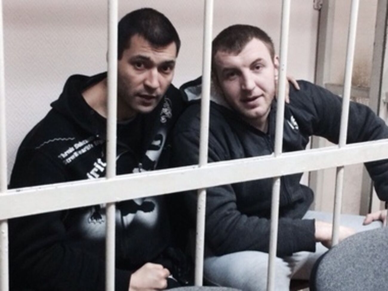 Денис Подымкин за решеткой (слева)