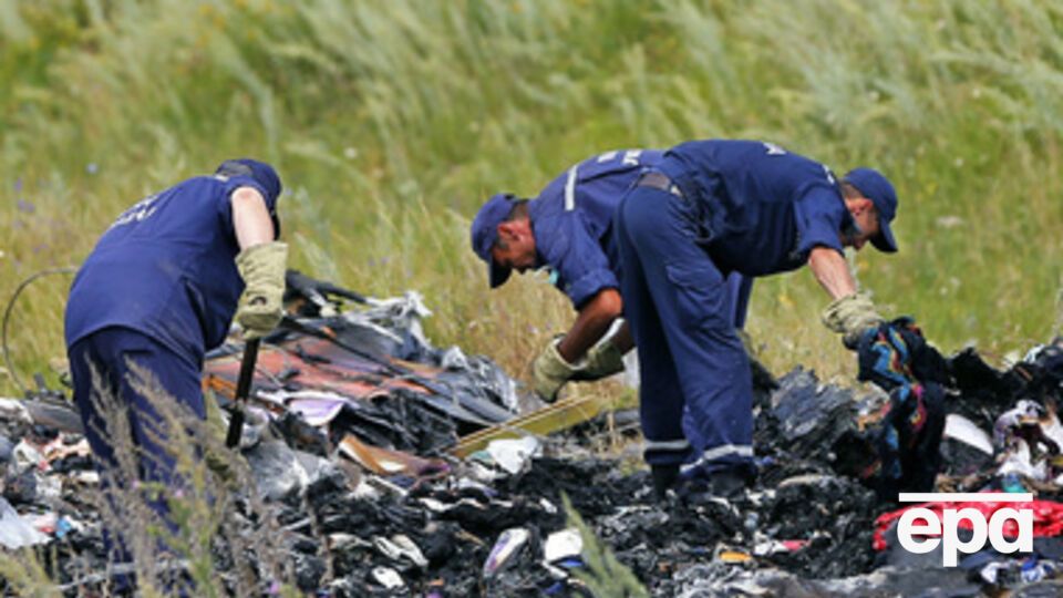 Украинские спасатели осматривают обломки на месте крушения Boeing 777