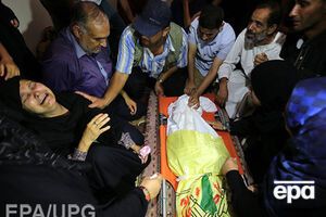 Палестинская женщина плачет над погибшим во время израильской бомбардировки сыном