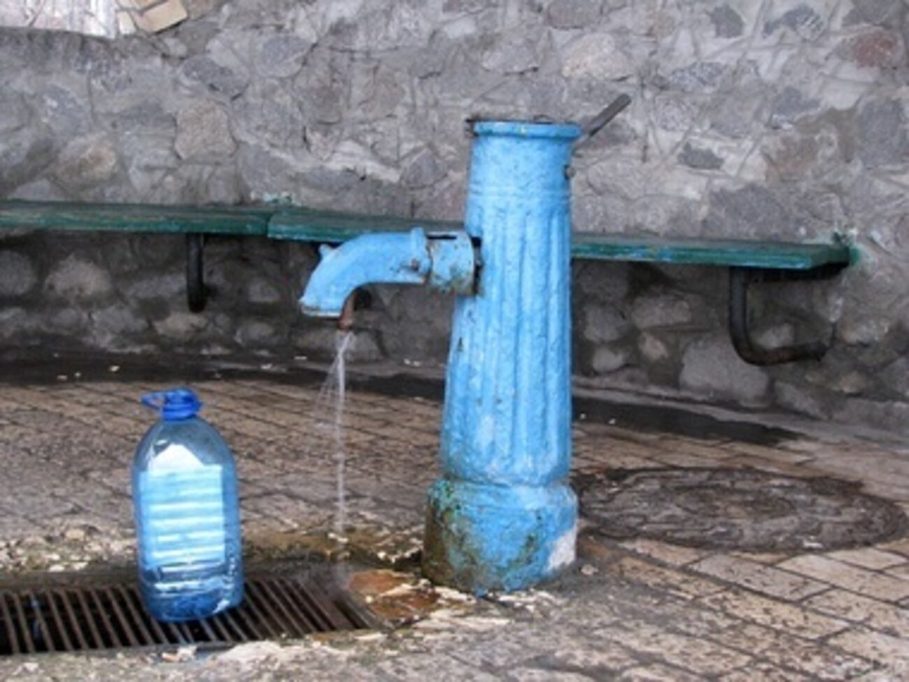 Местные жители набирают воду в бювете возле поселкового рынка