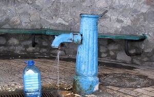 Местные жители набирают воду в бювете возле поселкового рынка