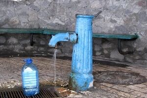 Местные жители набирают воду в бювете возле поселкового рынка