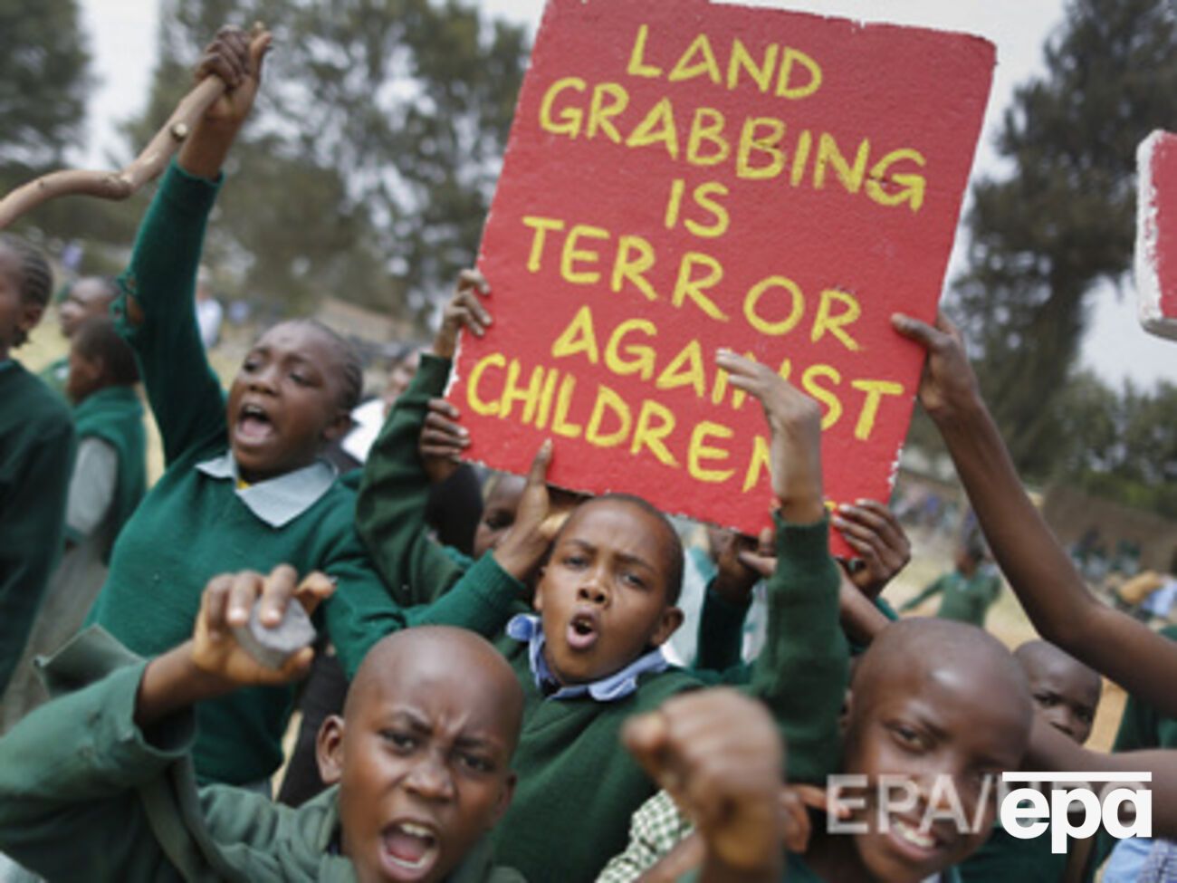 Дети держали плакаты, которые называли конфискацию детской площадки "Террором против детей", а Кению "Землей бесстыдных хапуг"