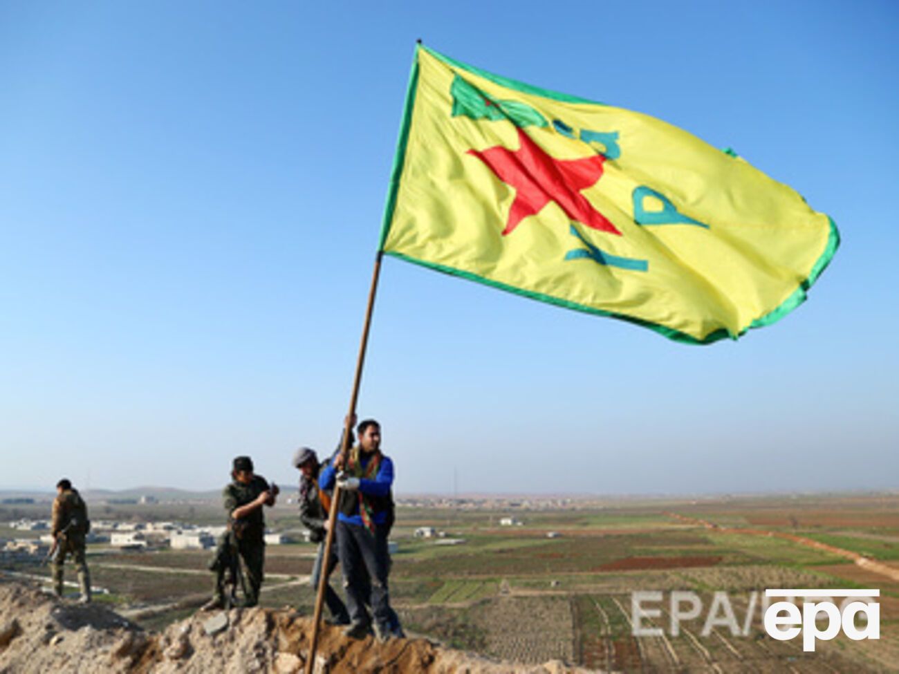Курды устанавливают свой флаг над холмом в Кобани