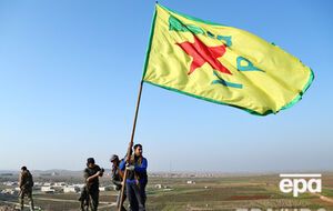 Курды устанавливают свой флаг над холмом в Кобани