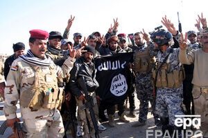 Иракские солдаты несут разорванный флаг "Исламского государства" после освобождения города Аль-Фурат