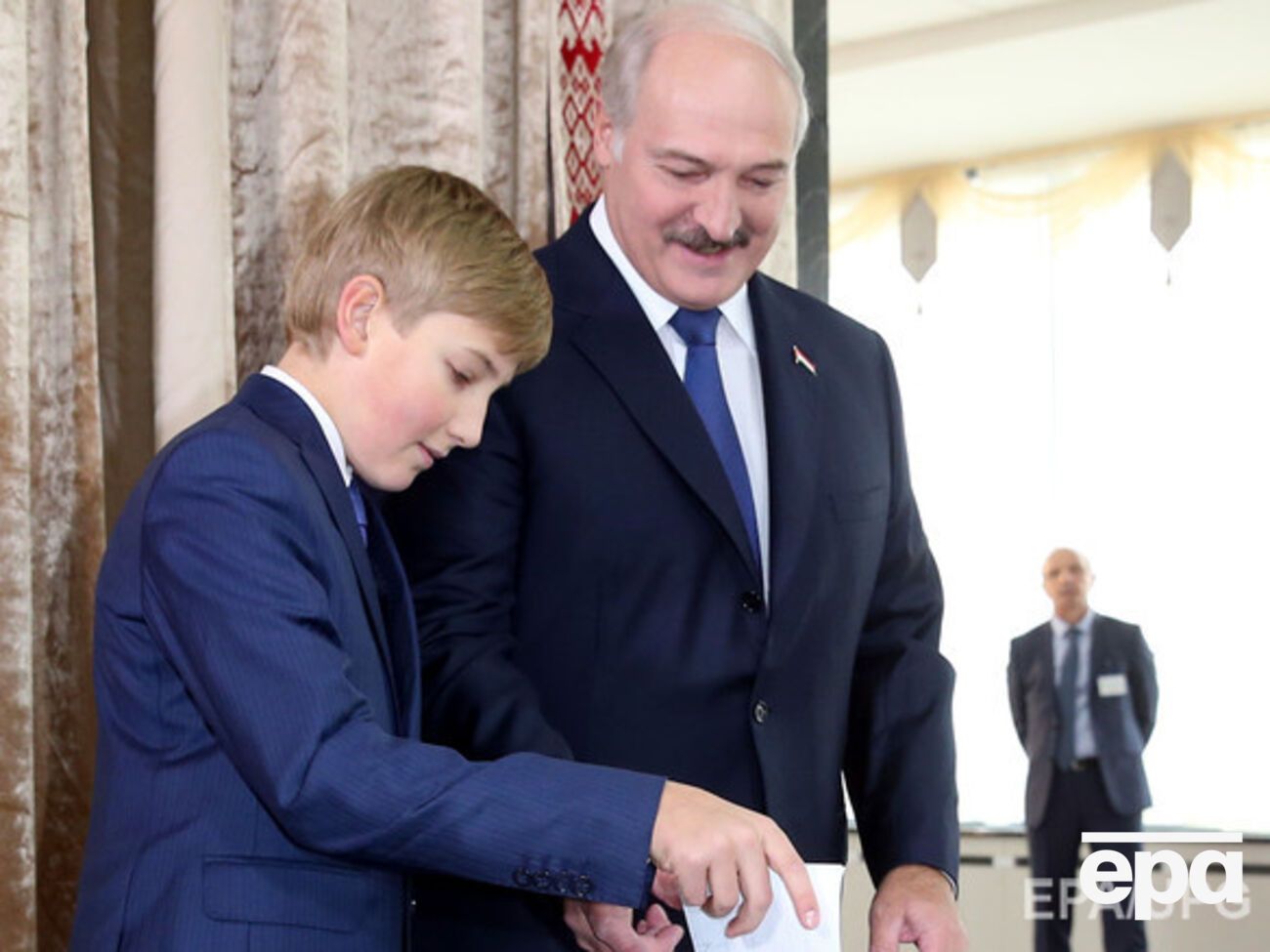 Президент Беларуси Александр Лукашенко голосует со своим младшим сыном Николаем на избирательном участке во время президентских выборов в Минске