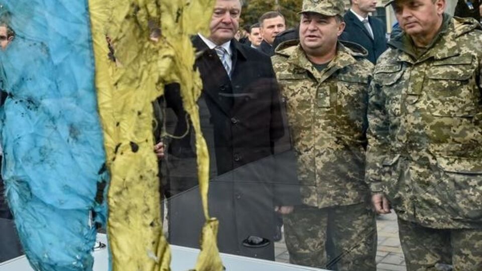 Порошенко смотрит на флаг, расстрелянный под Иловайском