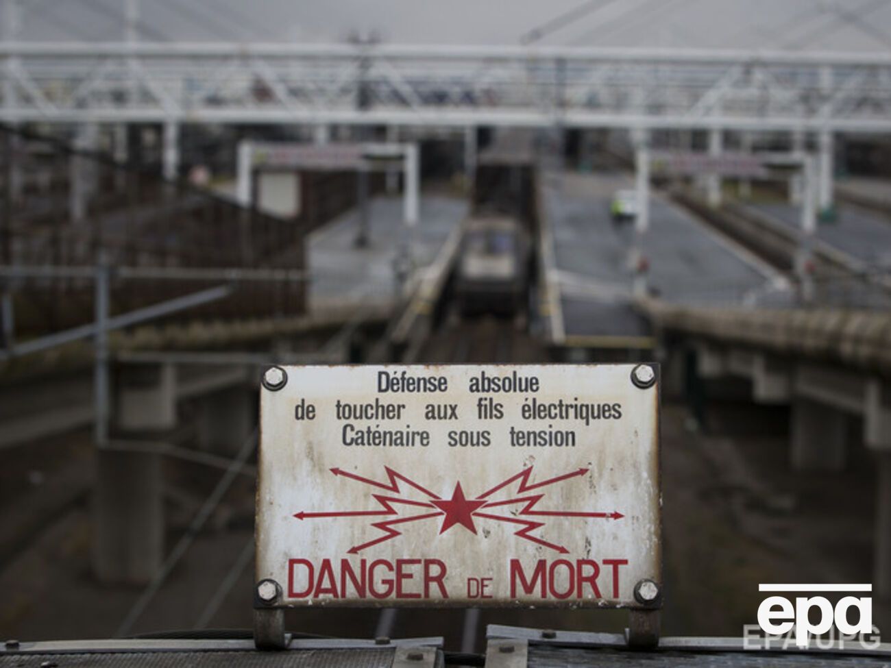 С французской стороны Евротоннеля размещены объявления, предупреждающие об опасности поражения электротоком при попытке проникнуть в тоннель