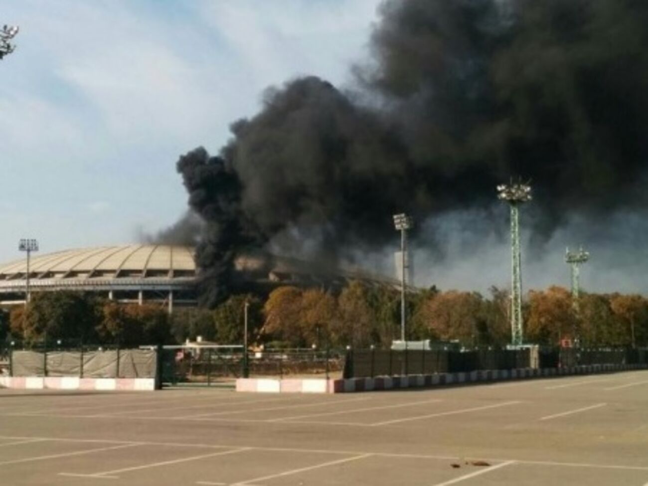 Столб черного дыма поднимается над московским стадионом на десятки метров