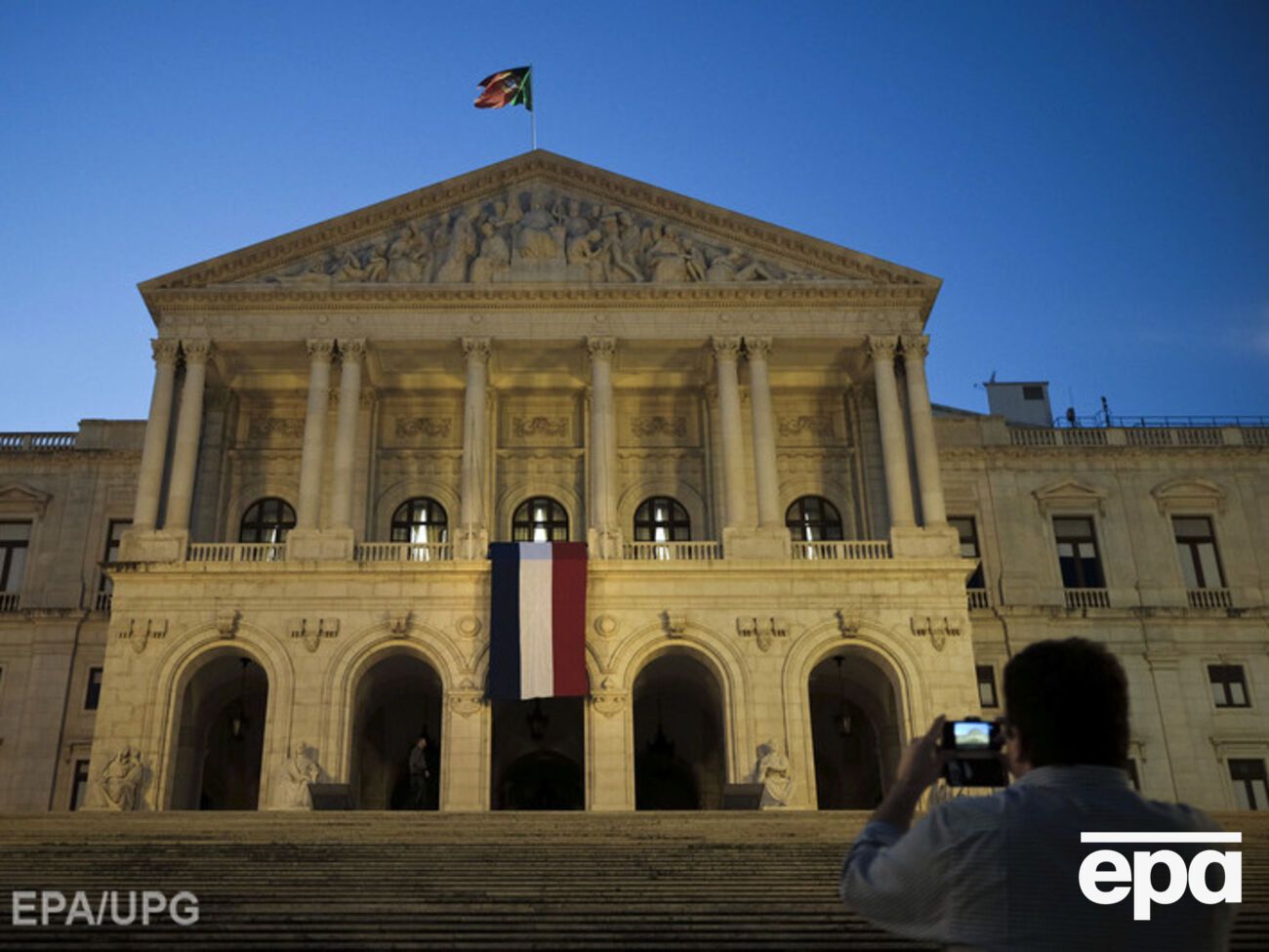 Французский флаг на здании парламента Португалии в знак скорби по погибшим