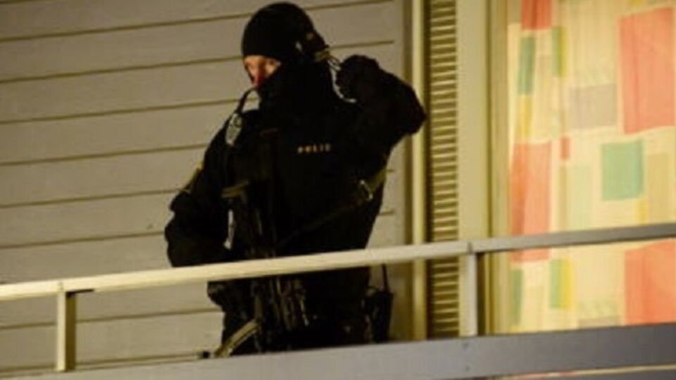 Полицейский на балконе здания, где задержали подозреваемого