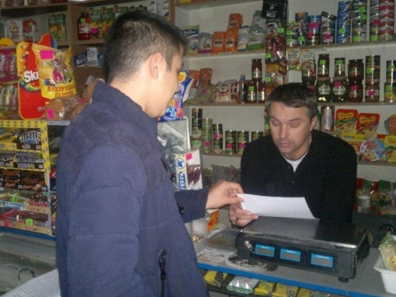 Представители оккупационных "властей" Крыма вручают торговцам "памятки" о запрете освещения витрин