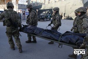 Британские военные, пришедшие на помощь, выносят тело погибшего испанского полицейского