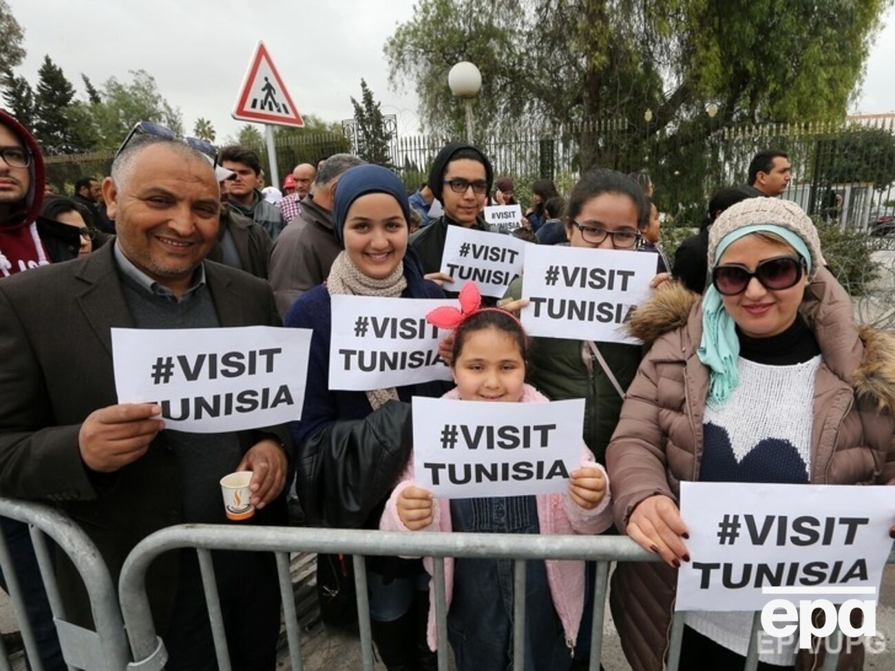 Участники марша против терроризма держат плакаты, гласящие "Посетите Тунис"