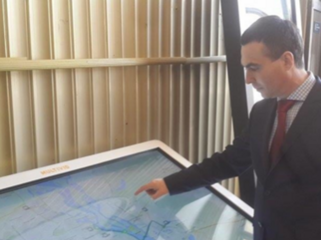 Глава КП "Киевпастранс" Сергей Майзель рядом с мультимедийным табло, которое будет установлено в зале фуникулера