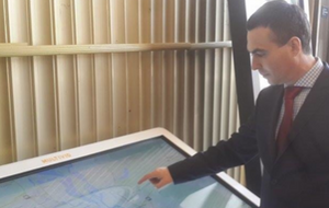 Глава КП "Киевпастранс" Сергей Майзель рядом с мультимедийным табло, которое будет установлено в зале фуникулера