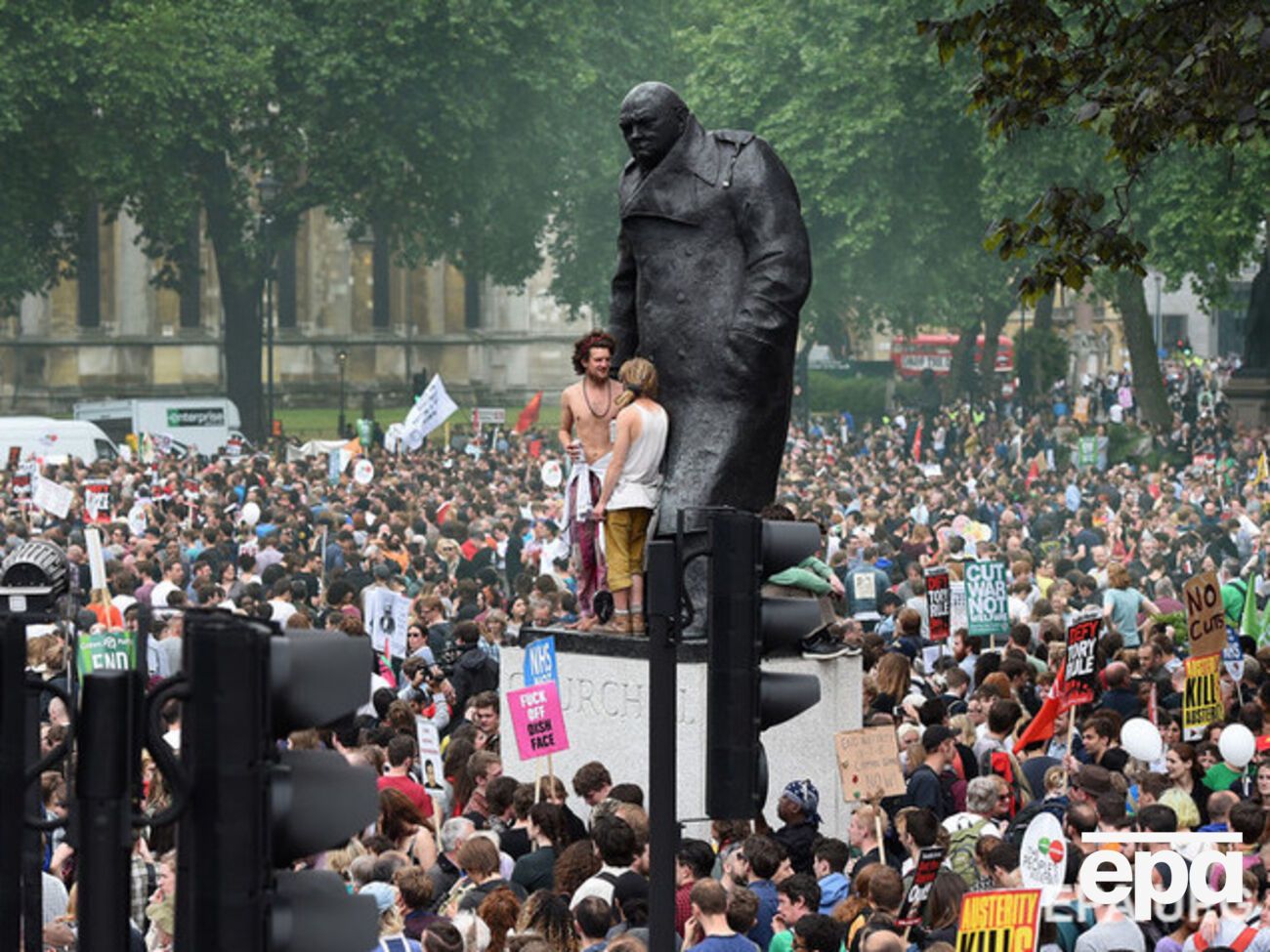 Протестующие против мер жесткой экономии возле памятника Уинстону Черчиллю в Лондоне