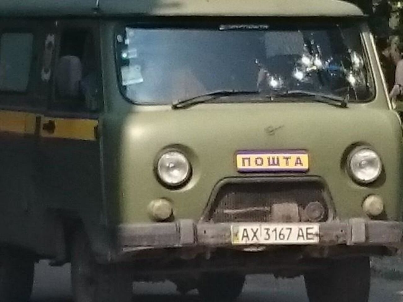 В лобовом стекле автомобиля видны шесть пулевых отверстий