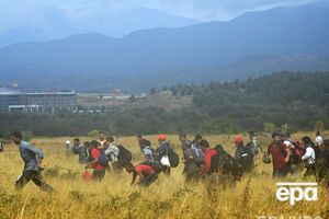 Мигранты, прорвавшиеся через колючую проволоку, бегут по полю в сторону македонского города Гевгелия