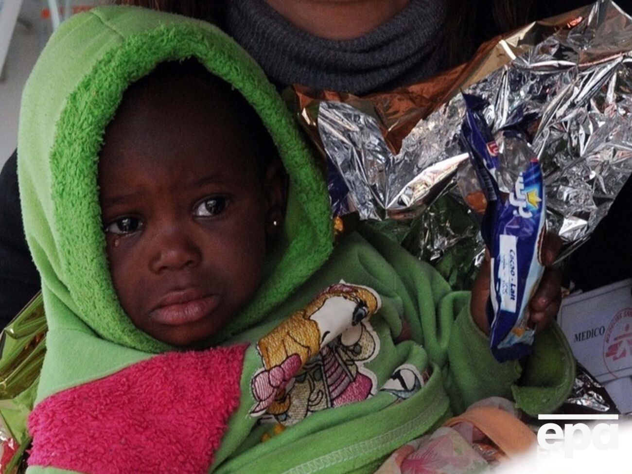 Спасенный в Средиземном море африканский ребенок-мигрант ожидает решения своей судьбы в лагере для нелегальных мигрантов на итальянском острове Лампедуза