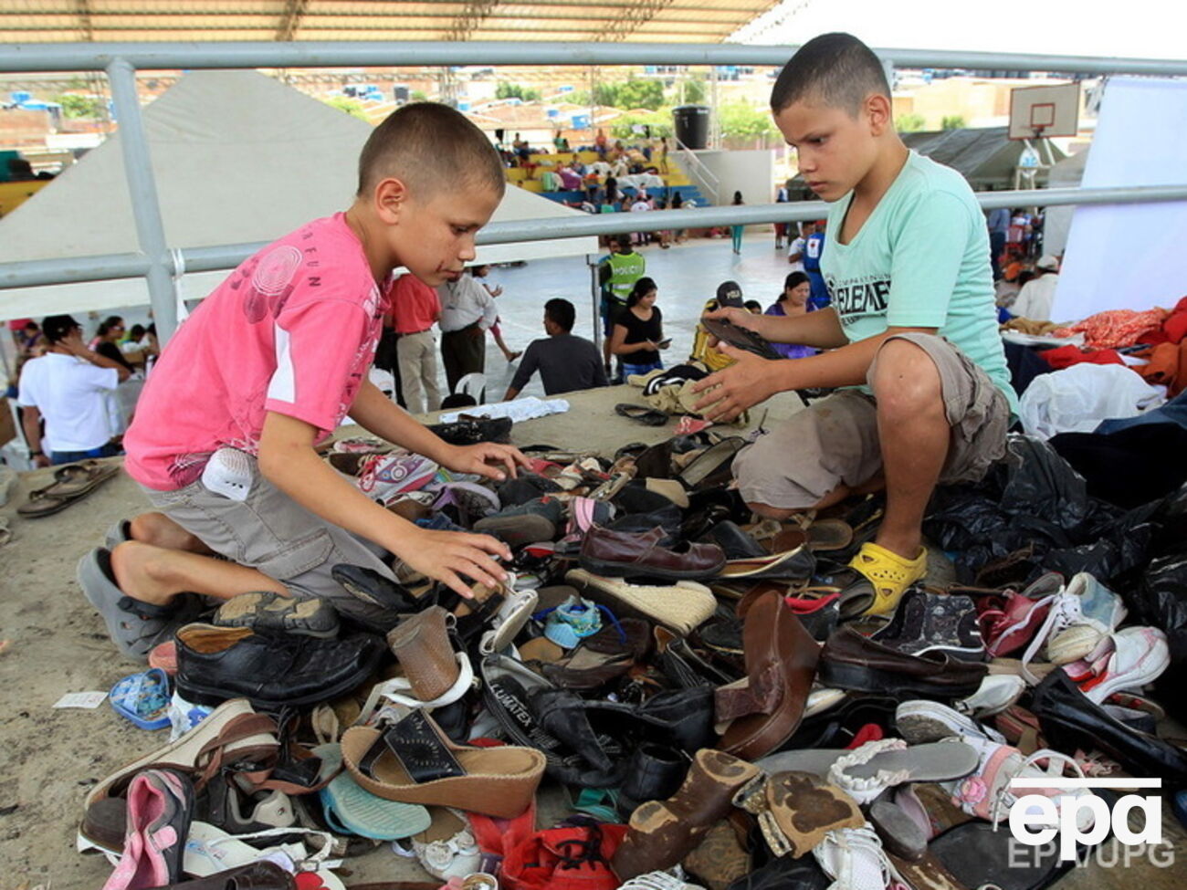 Депортированные колумбийские дети выбирают обувь из гуманитарной помощи в убежище Эль Морикаль, в Кукута (Колумбия), на границе с Венесуэлой