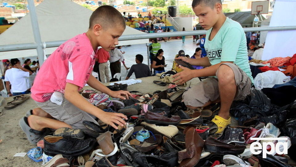 Депортированные колумбийские дети выбирают обувь из гуманитарной помощи в убежище Эль Морикаль, в Кукута (Колумбия), на границе с Венесуэлой