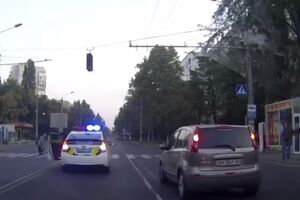 Полицейский остановился на дороге, чтобы перевести через дорогу старушку