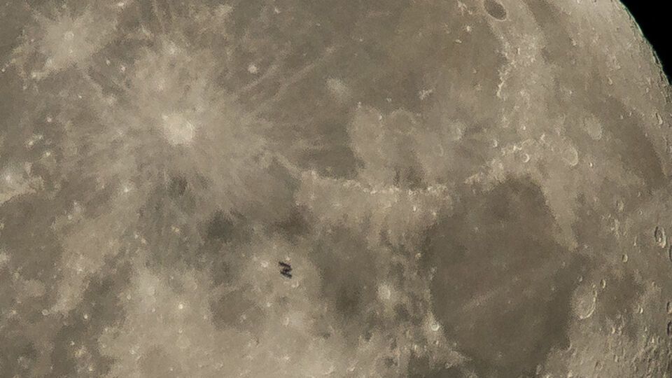 Станция едва видна на фоне Луны
