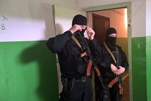 Вооруженные силовики охраняют вход в квартиру Сиротюка во время обыска