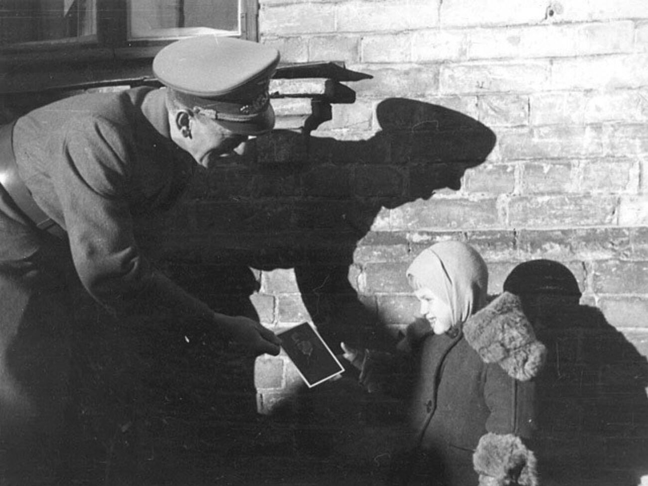 Немецкий офицер дарит украинской девочке портрет Гитлера. Киев, осень 1941 года