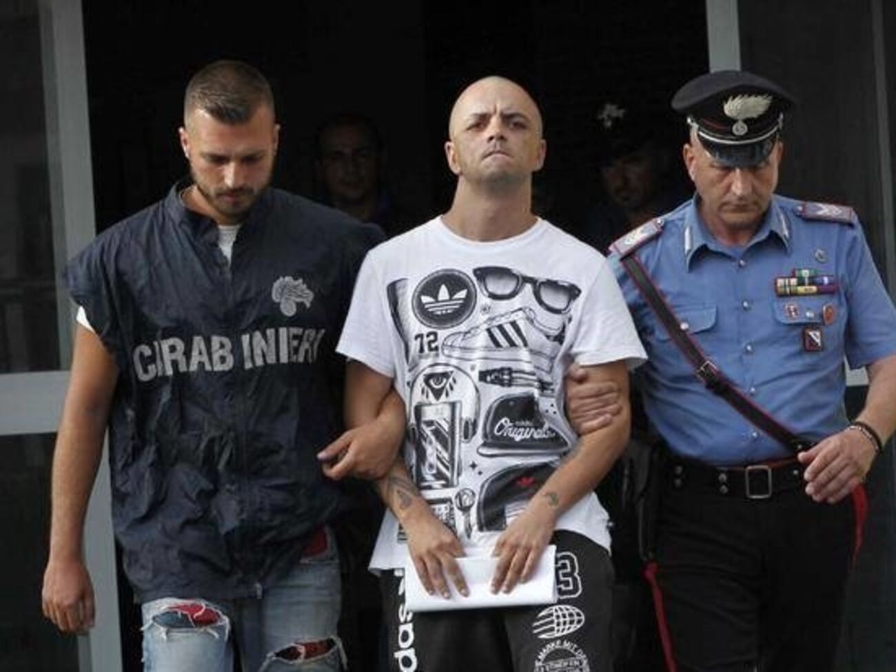 Карабинеры ведут задержанного Марко ди Лоренцо к полицейскому автомобилю