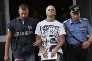 Карабинеры ведут задержанного Марко ди Лоренцо к полицейскому автомобилю