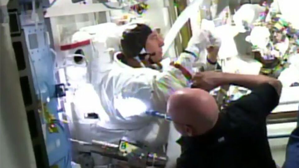 Командир МКС Скотт Келли помогает снять скафандр Тимоти Копре