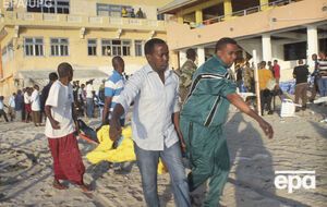 Мужчины несут тело погибшего при нападении террористов на ресторан