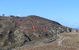 Знак выложен на холме у моря