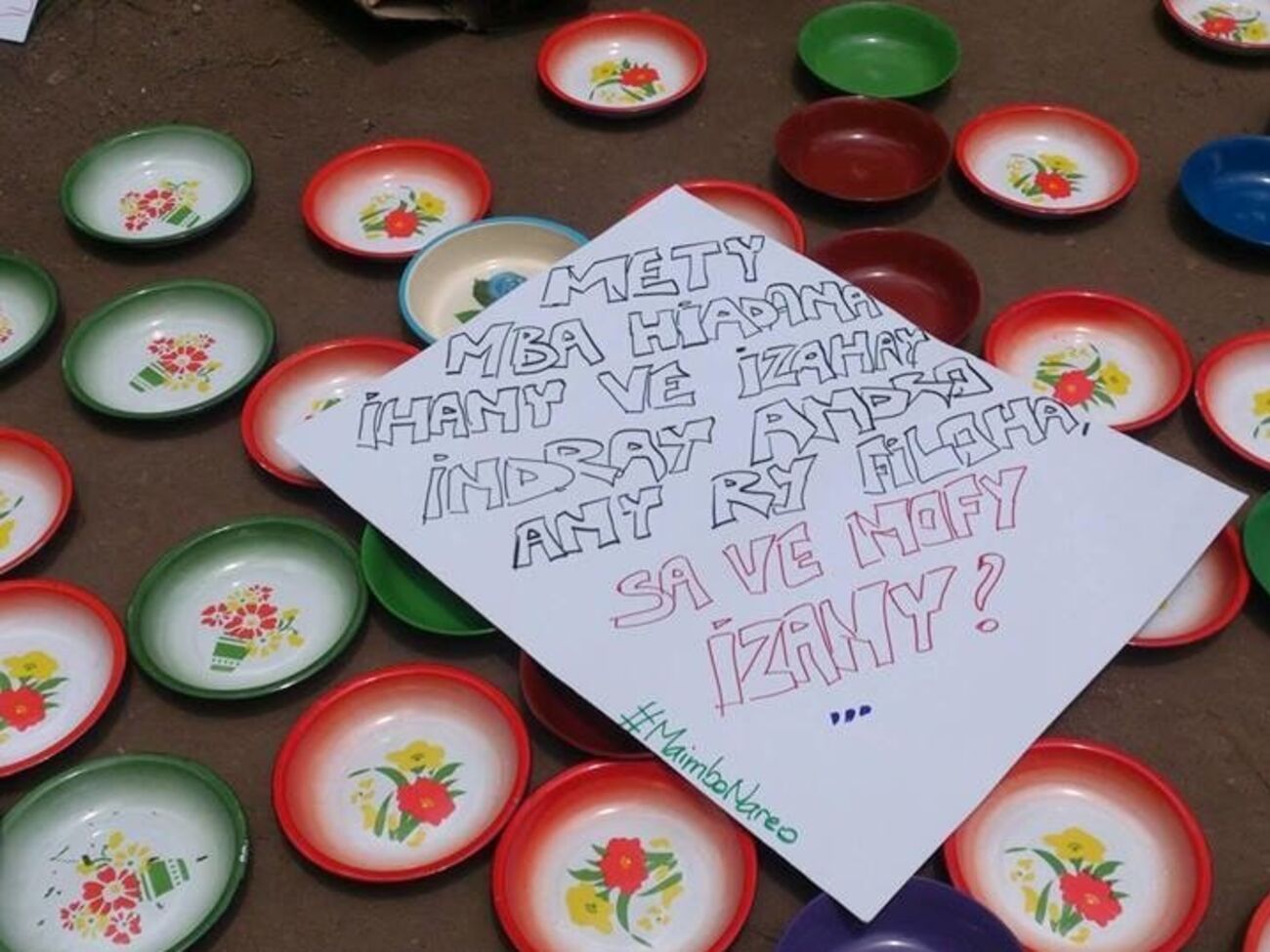 На пустых тарелках активисты разложили плакаты с требованиями не злоупотреблять народными деньгами