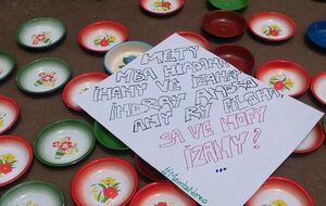 На пустых тарелках активисты разложили плакаты с требованиями не злоупотреблять народными деньгами