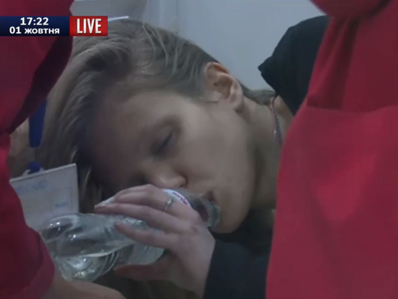 Подозреваемая Вита Заверуха во время заседания лежит на скамье, ее поят водой