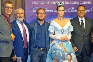В руке глава России держит Землю, а сзади на платье нарисован храм Василия Блаженного