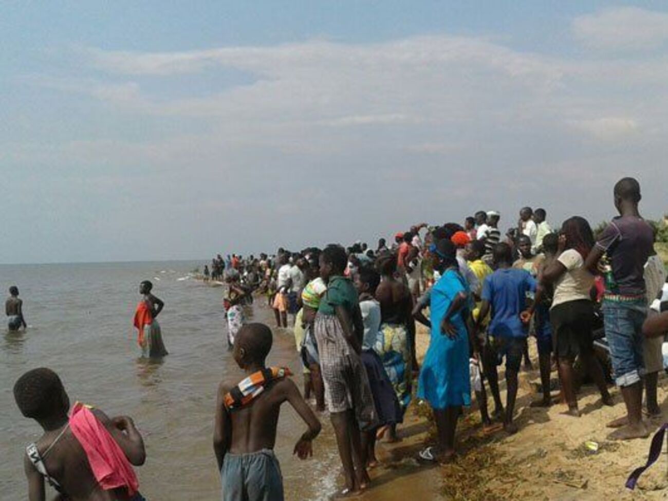 Местные жители следят за спасательной операцией на озере Альберт